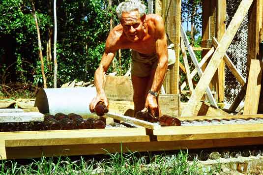 Bob Hemus setting bottles into morter, starting the house walls 